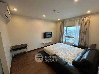 Modern bedroom with city view, featuring sleek furniture and ambient lighting.