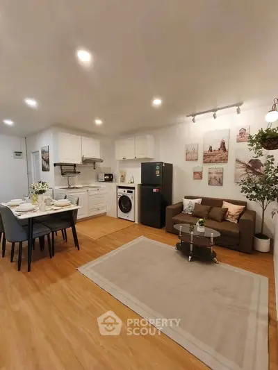 Charming open-plan living room with dining area and modern kitchen appliances.