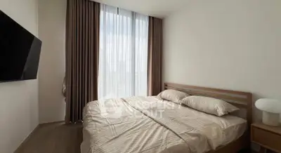 Modern bedroom with large window and stylish decor in a contemporary apartment.