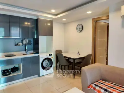 Modern kitchen with sleek cabinets and integrated washing machine in cozy apartment.