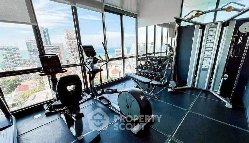 Luxurious high-rise gym with panoramic city views and modern fitness equipment.
