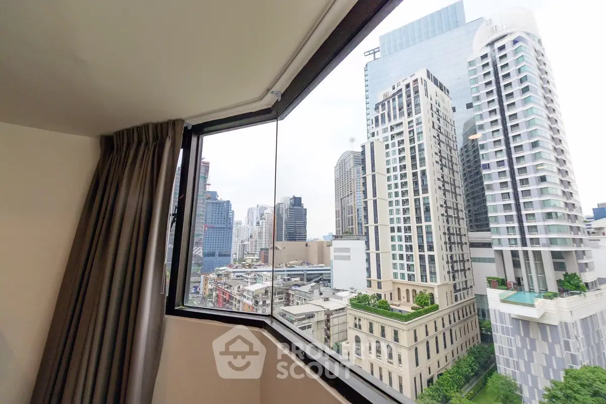 Stunning cityscape view from a high-rise apartment window, showcasing modern urban architecture.