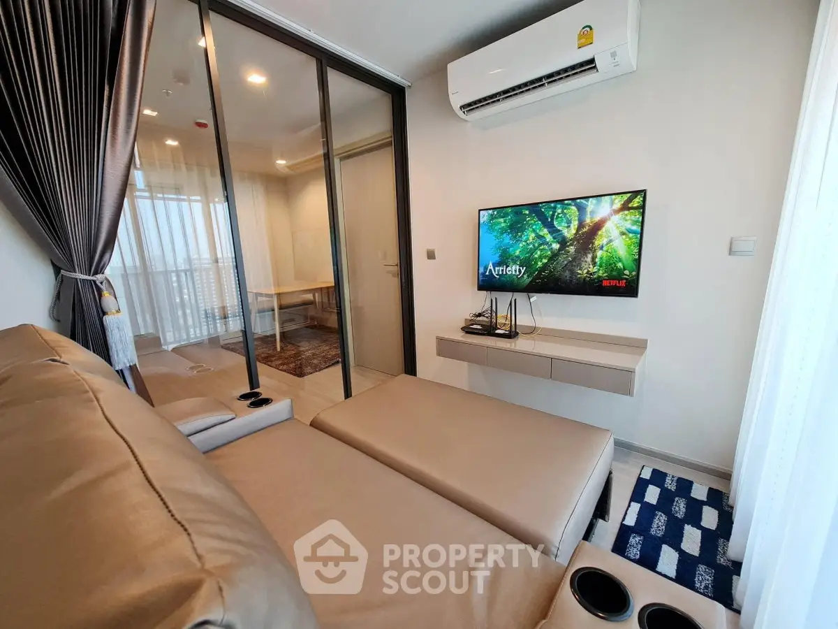 Modern living room with sleek furniture and wall-mounted TV in a stylish apartment.