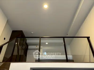 Modern loft bedroom with glass railing and minimalist design