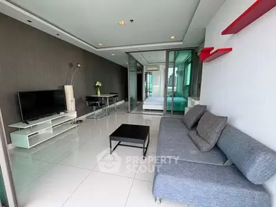 Modern living room with sleek design and glass partition leading to bedroom