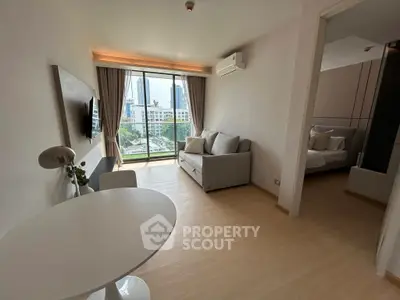 Modern living room with city view, featuring sleek furniture and natural light.