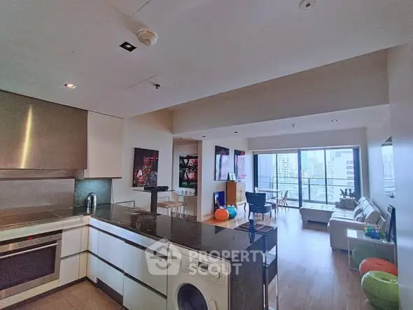 Spacious modern living room with open kitchen and city view balcony.