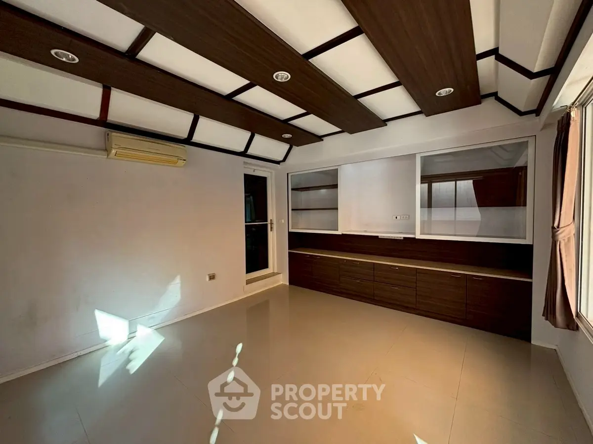 Spacious modern living room with sleek built-in cabinets and stylish ceiling design.