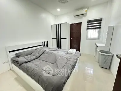 Modern bedroom with sleek design and air conditioning, featuring a comfortable bed and ample storage.