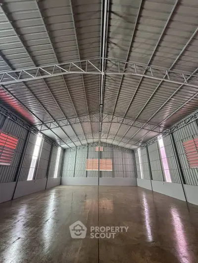 Spacious industrial warehouse with high ceilings and ample natural light.