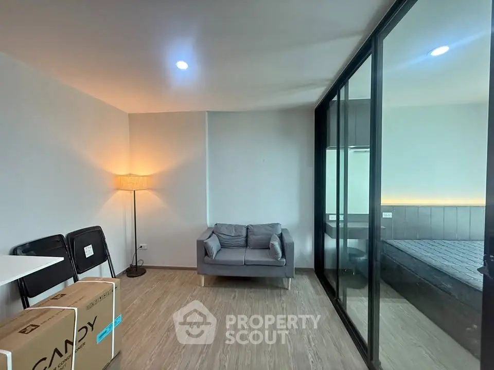 Modern apartment with cozy living area and glass partitioned bedroom