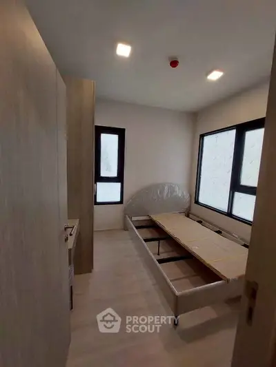 Cozy bedroom with natural light and modern minimalist design, perfect for relaxation and comfort.