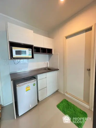 Compact modern kitchen with microwave and mini fridge in cozy apartment