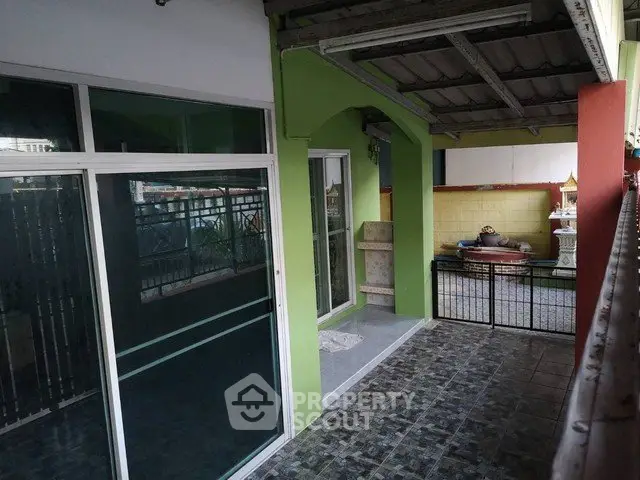 Spacious balcony with tiled flooring and green accents, perfect for outdoor relaxation.