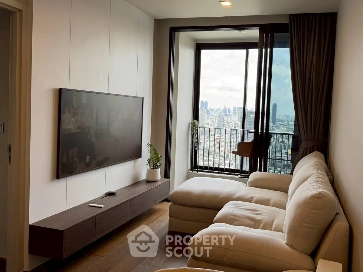 Modern living room with city view, cozy sofa, and wall-mounted TV in high-rise apartment.