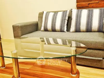 Modern living room with stylish gray sofa and glass coffee table