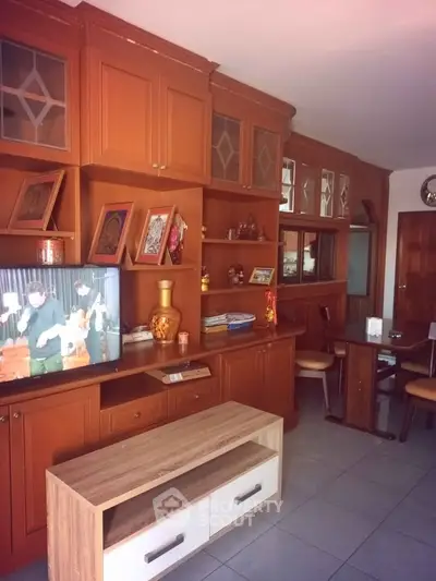 Spacious living room with elegant wooden cabinetry and modern entertainment setup.