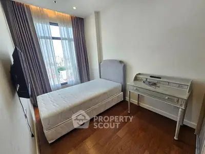 Cozy bedroom with single bed and elegant desk, featuring large window with city view.