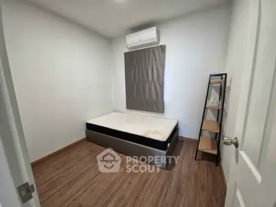 Cozy minimalist bedroom with air conditioning and wooden flooring