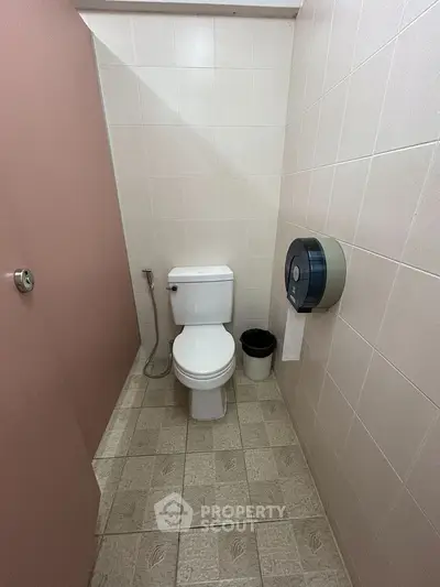 Compact bathroom with toilet and tiled floor, ideal for small spaces.