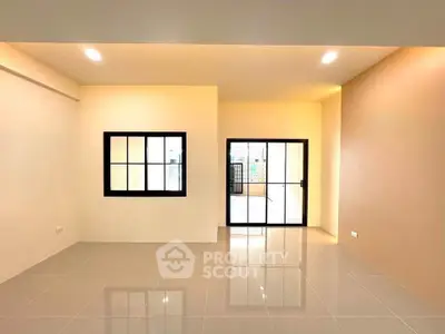 Spacious modern living room with large windows and glossy tiled floor