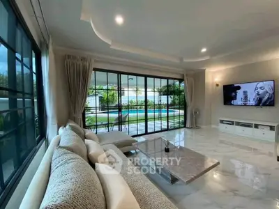 Luxurious living room with pool view, modern decor, and elegant marble flooring.