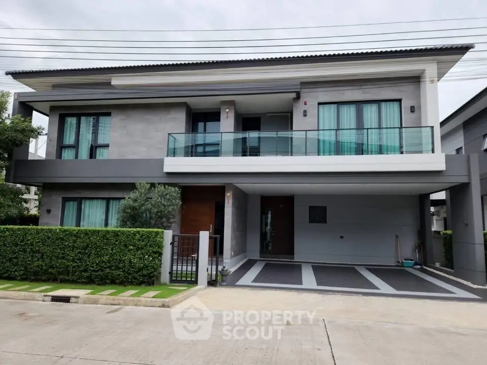 Modern two-story house with sleek design and spacious balcony in a serene neighborhood.