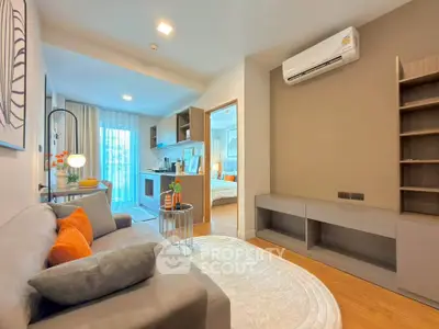 Modern living room with cozy sofa, open kitchen, and stylish decor in a contemporary apartment.