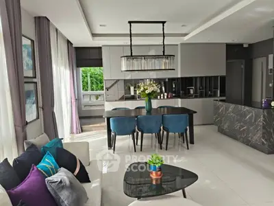 Luxurious modern living room with open kitchen, elegant decor, and abundant natural light.