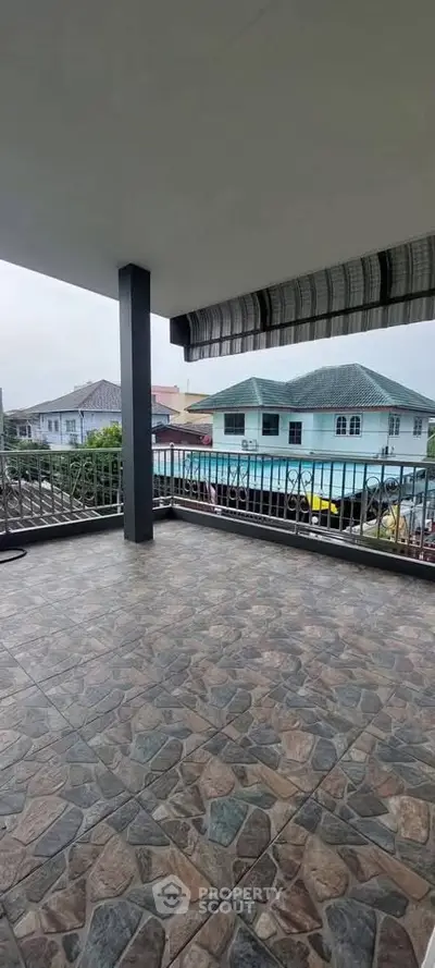 Spacious balcony with tiled flooring and neighborhood view, perfect for outdoor relaxation.