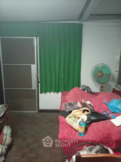 Cozy living room with red sofa and green curtains, ideal for relaxation.