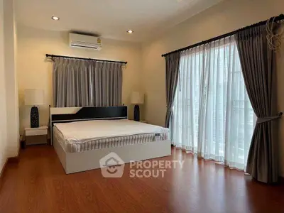 Spacious bedroom with large windows and elegant curtains in modern home