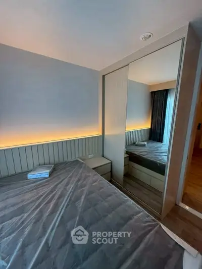Modern bedroom with mirrored wardrobe and ambient lighting