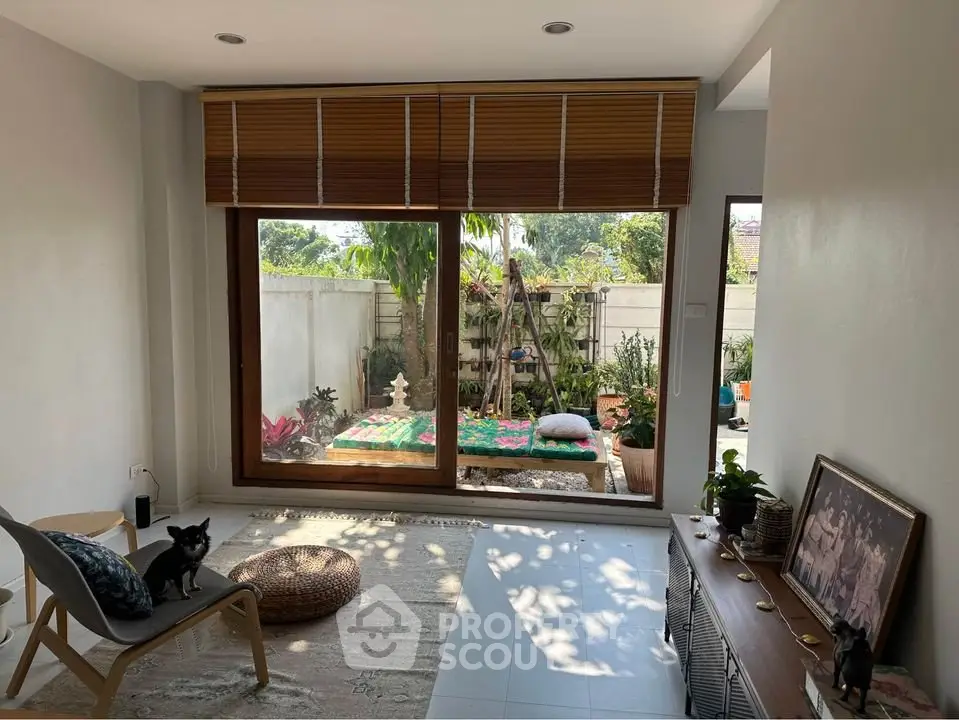Charming living room with garden view, featuring cozy seating and abundant natural light.