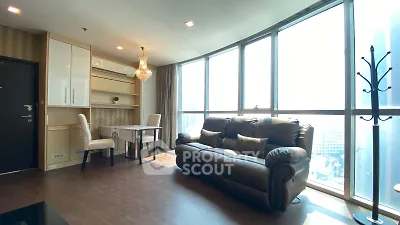 Luxurious living room with floor-to-ceiling windows and elegant furnishings in a high-rise apartment.