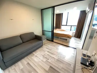 Modern apartment with open layout featuring cozy living room and bedroom with large windows.