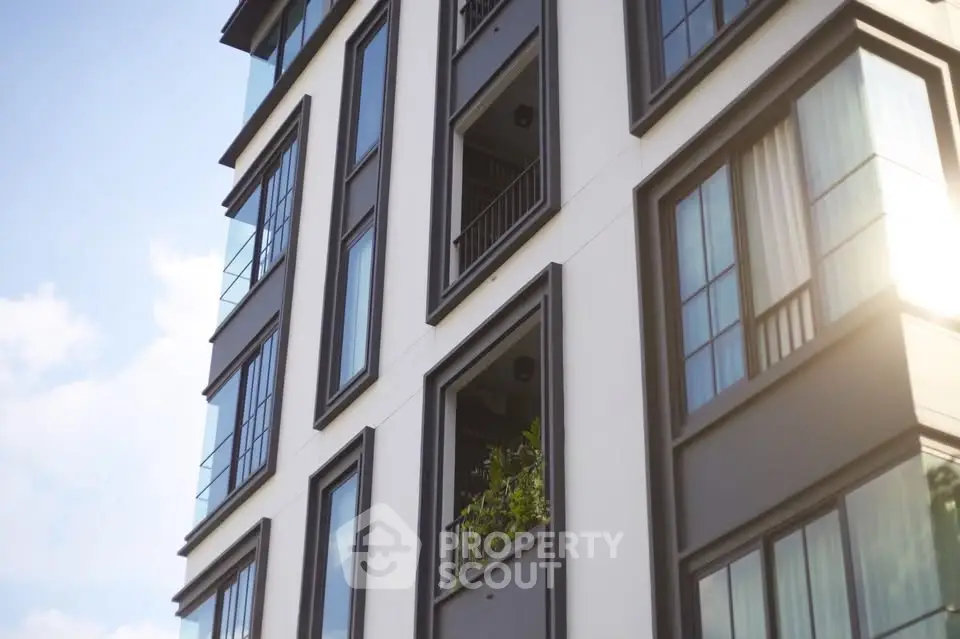 Modern apartment building exterior with large windows and balconies, showcasing contemporary architectural design.