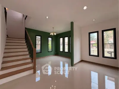 Spacious modern living room with elegant staircase and large windows