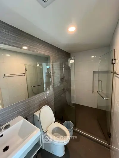 Modern bathroom with glass shower and sleek fixtures in a contemporary apartment.