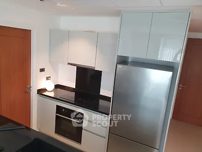 Modern kitchen with sleek cabinetry and stainless steel appliances in a contemporary apartment.