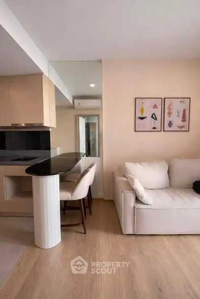 Modern living room with sleek kitchen and cozy sofa, perfect for urban living.
