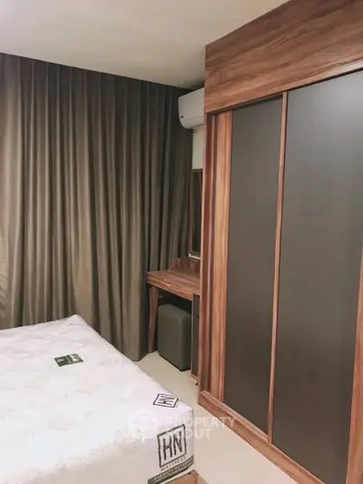 Cozy bedroom with elegant wooden wardrobe and stylish curtains in modern apartment.