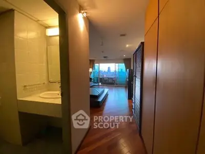 Stylish apartment hallway leading to a cozy living room with city view balcony.