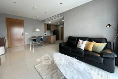 Modern living room with sleek furniture and open kitchen layout in a stylish apartment.