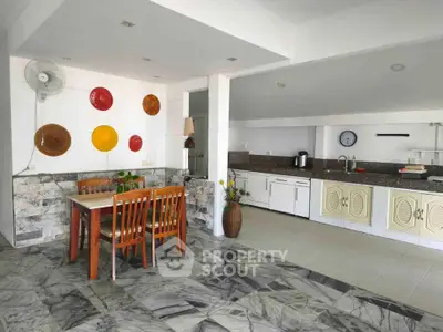 Spacious open-layout kitchen and dining area with modern decor and marble flooring.