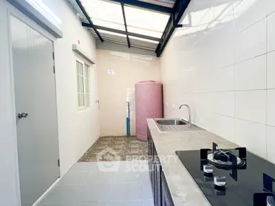 Modern kitchen with sleek gas stove and spacious layout, featuring a covered outdoor area for versatile use.