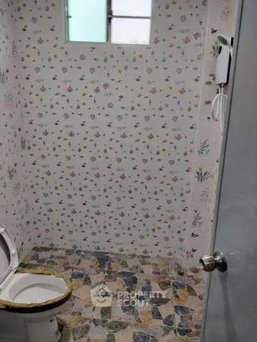 Charming bathroom with floral wallpaper and colorful tiled floor, perfect for a cozy home ambiance.