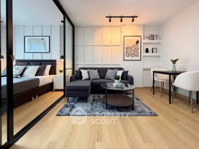 Modern open-plan living room with stylish decor and cozy bedroom area