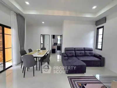 Modern living room with sleek furniture and dining area in open layout