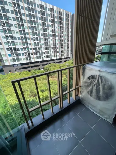 Modern balcony with city view and greenery, perfect for relaxation.